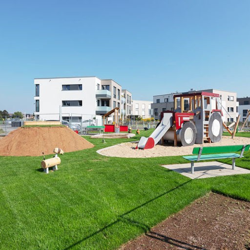 Spielplatz mit Rutsche vor Wohngebäude