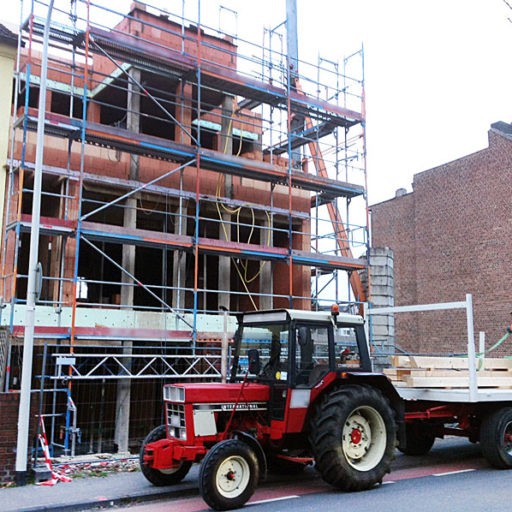 Traktor vor Hausbau mit Gerüst