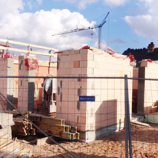 Baustelle mit Kran und unfertigem Haus